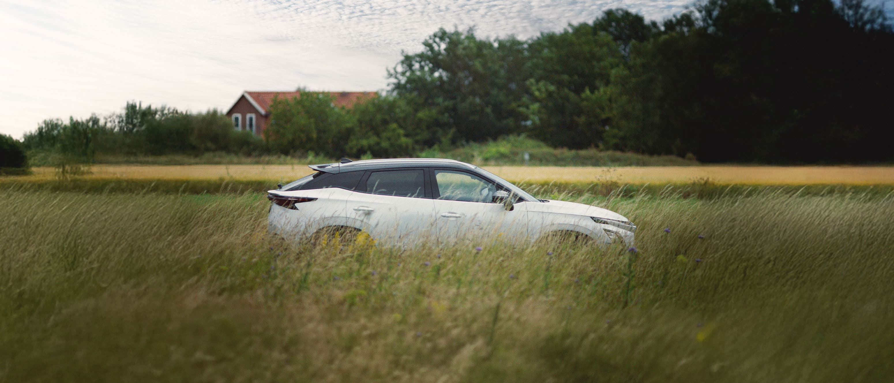 OMODA 5 EV Premium kører på en landevej igennem marker